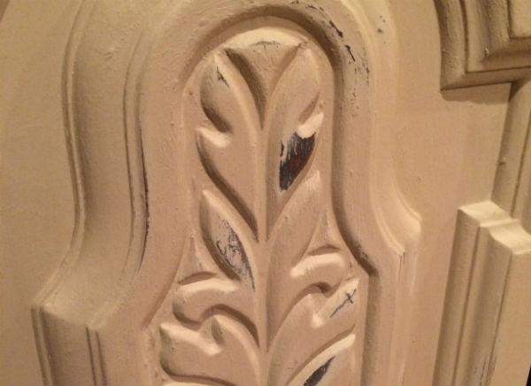 Using sandpaper to distress painted furniture.