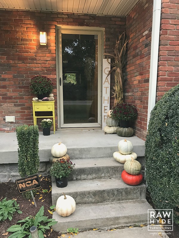 Image of my fall porch decor, including the mum pots I painted to save money on new pots!